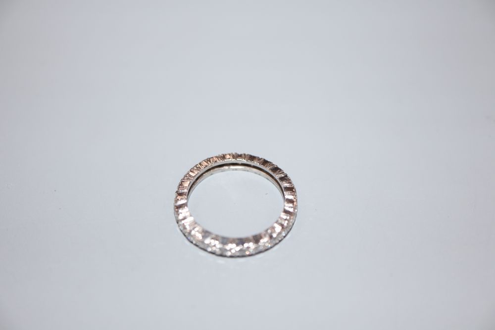 A white metal and diamond set full eternity ring, size M, gross 3.3 grams.